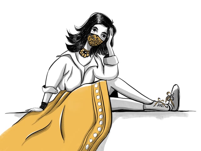 Woman in a white blouse, yellow skirt, and patterned face covering seated with one leg extended.