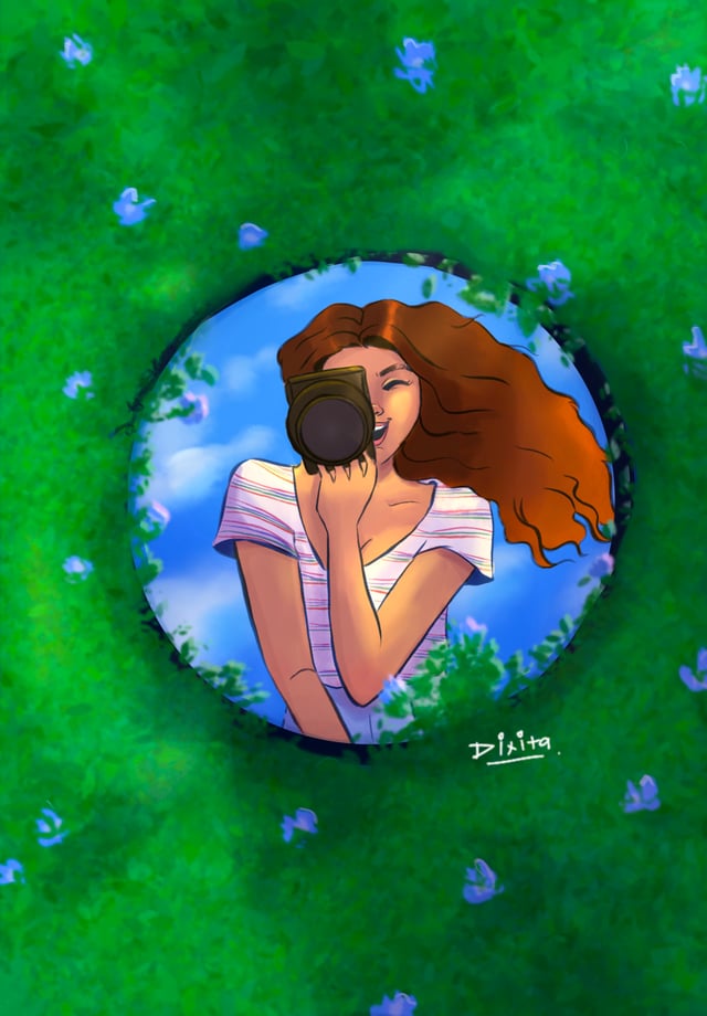 Round mirror lying in green grass and reflecting a woman leaning over it.